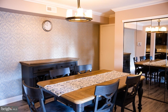 dining area with an inviting chandelier, crown molding, and hardwood / wood-style floors