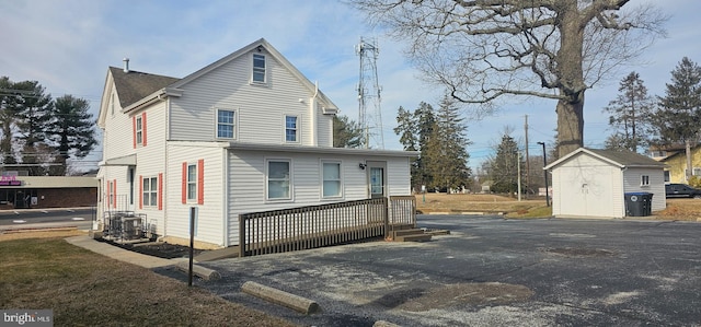 view of front of property featuring a storage shed