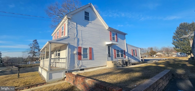 view of side of home with a lawn and a porch