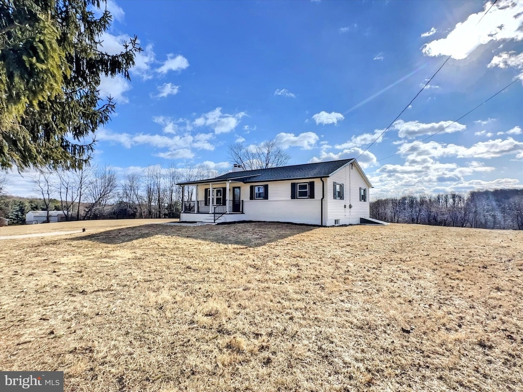 back of house featuring a porch and a yard