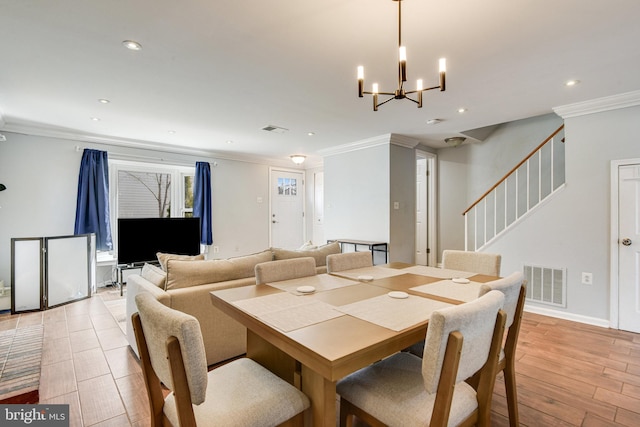 dining space featuring light hardwood / wood-style floors, an inviting chandelier, and ornamental molding