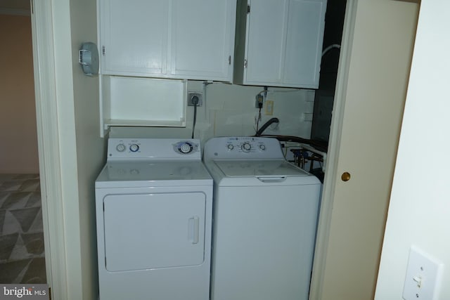 clothes washing area featuring cabinet space and independent washer and dryer