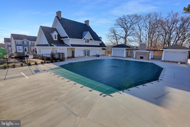 community pool featuring a patio area, a fireplace, and fence