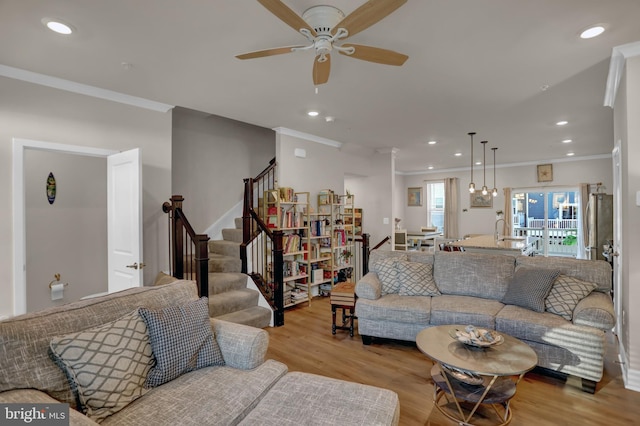 living area featuring recessed lighting, a ceiling fan, ornamental molding, stairway, and light wood finished floors