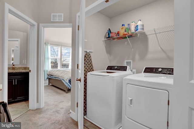 laundry room featuring laundry area, visible vents, light colored carpet, and washing machine and clothes dryer