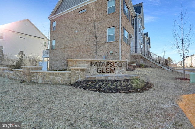 back of property with brick siding and stairway