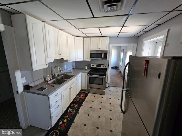 kitchen with stainless steel appliances, a sink, visible vents, white cabinets, and light floors