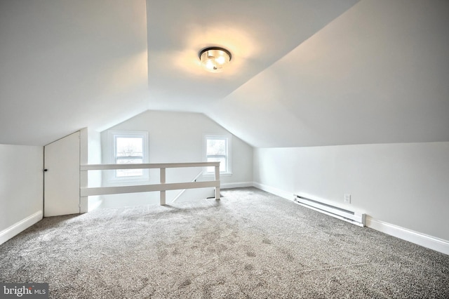 additional living space with vaulted ceiling, a baseboard radiator, and carpet