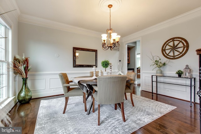 dining room featuring ornamental molding, dark hardwood / wood-style floors, and an inviting chandelier