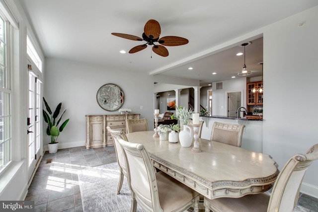 dining area featuring ceiling fan and decorative columns