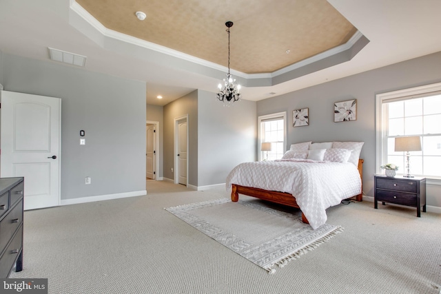 carpeted bedroom featuring a tray ceiling, crown molding, and a notable chandelier