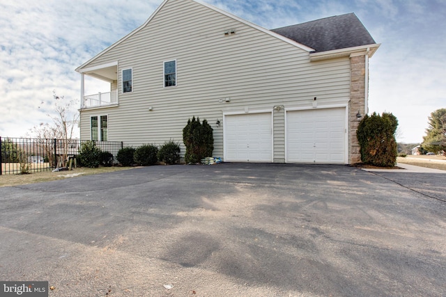 view of property exterior with a garage and a balcony