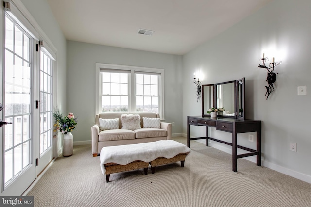 living area with a wealth of natural light and light colored carpet