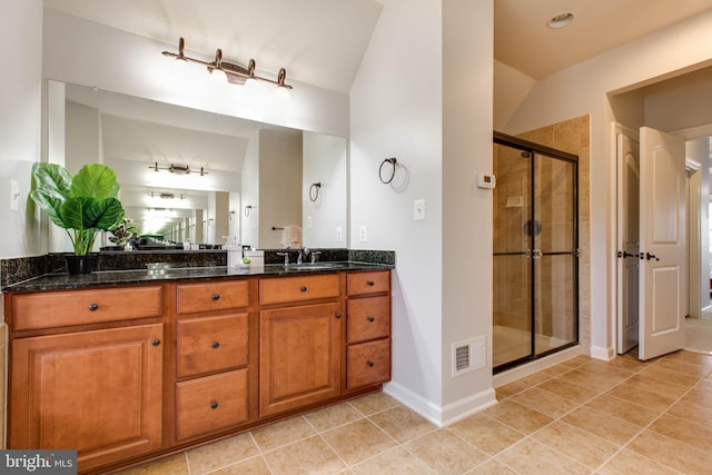 bathroom with lofted ceiling, tile patterned flooring, vanity, and a shower with door