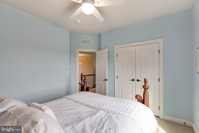 bedroom with light carpet, ceiling fan, and a closet