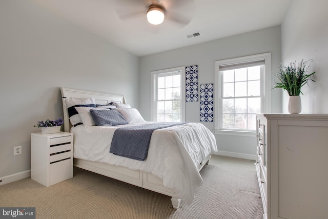 carpeted bedroom with multiple windows and ceiling fan