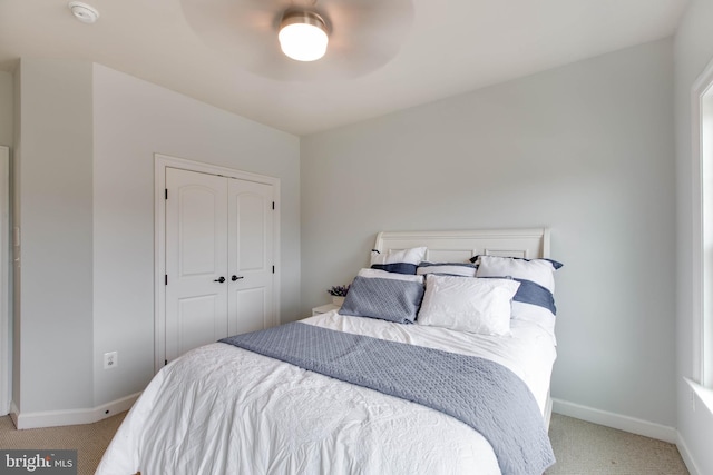 bedroom featuring ceiling fan, a closet, and light colored carpet