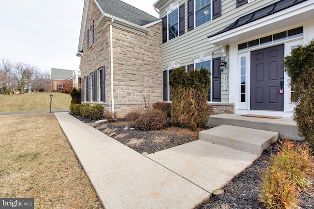 view of exterior entry with a yard