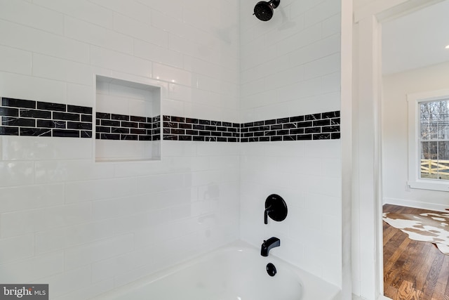 bathroom featuring wood finished floors and bathtub / shower combination