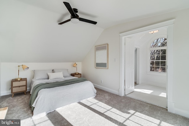 carpeted bedroom with baseboards, ceiling fan, and vaulted ceiling