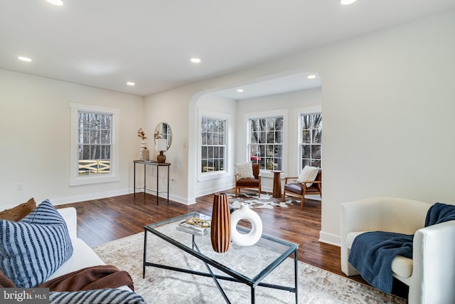 living area featuring arched walkways, recessed lighting, and wood finished floors