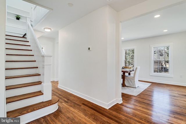 stairway featuring recessed lighting, wood finished floors, and baseboards