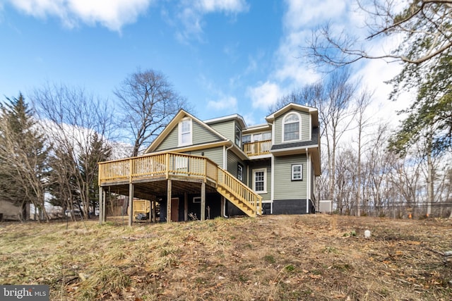 back of house with a wooden deck and stairs