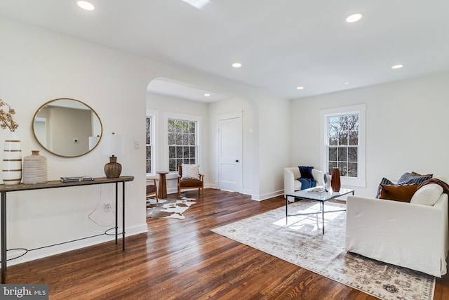 living room featuring recessed lighting, arched walkways, plenty of natural light, and wood finished floors