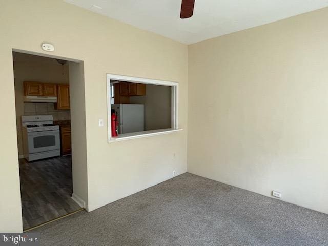 empty room with dark carpet and ceiling fan