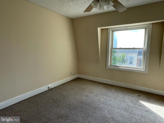 unfurnished room featuring ceiling fan, carpet floors, and a textured ceiling