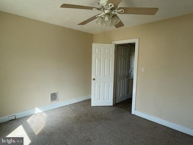 carpeted spare room with ceiling fan and a textured ceiling