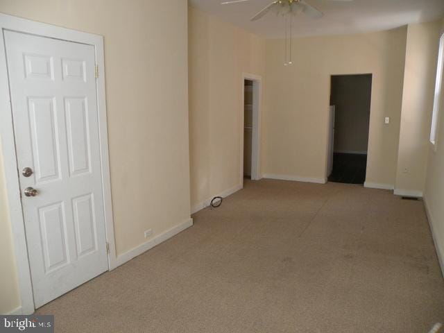 spare room featuring light carpet and ceiling fan