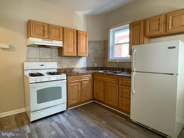 kitchen featuring dark hardwood / wood-style flooring, sink, white appliances, and backsplash