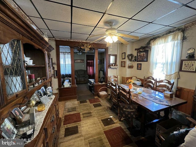 dining area with a drop ceiling and ceiling fan