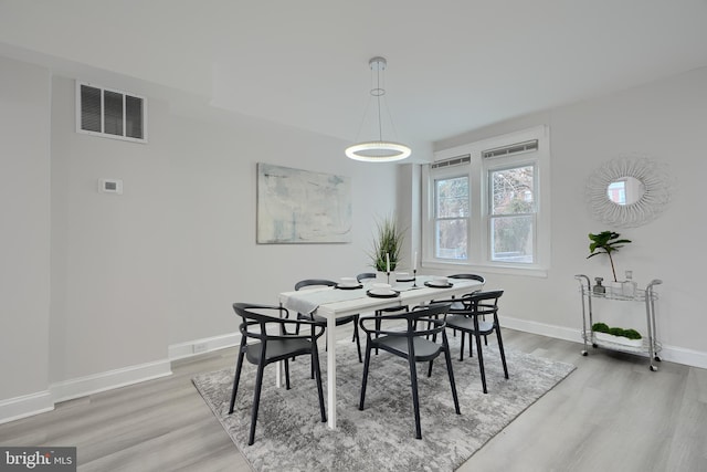 dining area featuring wood finished floors, visible vents, and baseboards