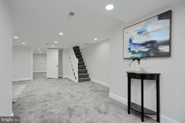 below grade area with recessed lighting, visible vents, light colored carpet, stairway, and baseboards