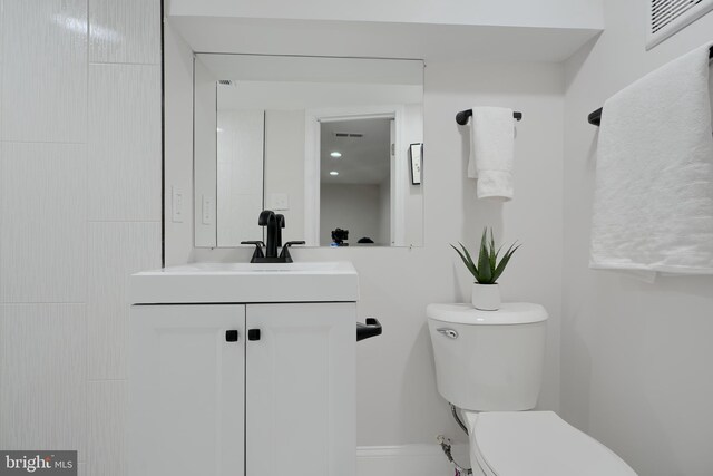 bathroom featuring visible vents, vanity, and toilet