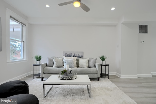 living room with baseboards, wood finished floors, visible vents, and recessed lighting