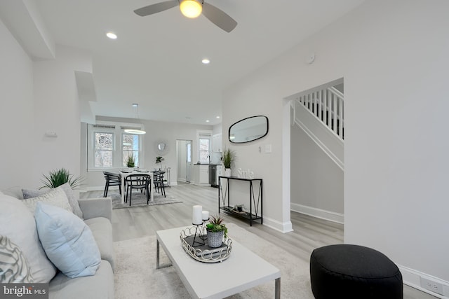 living area featuring light wood-style floors, baseboards, and recessed lighting