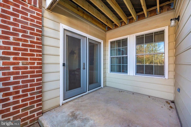 view of exterior entry with a patio area