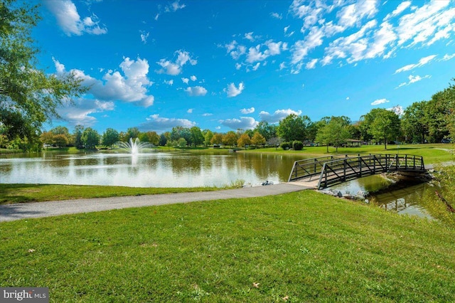 view of dock featuring a lawn and a water view