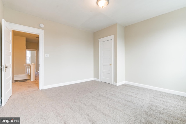 unfurnished bedroom with light colored carpet and baseboards