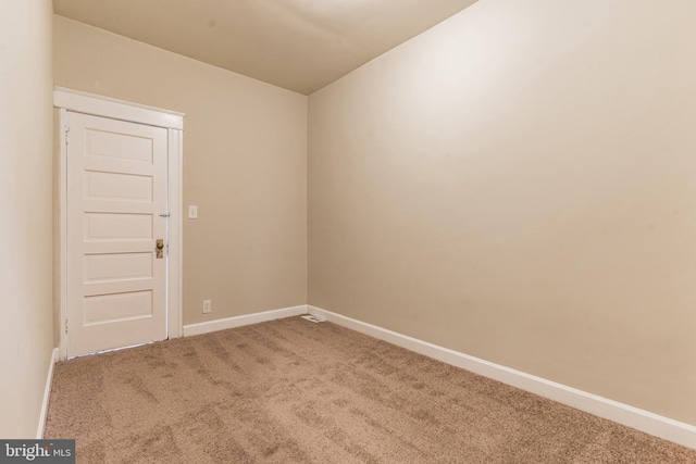 spare room with carpet and baseboards