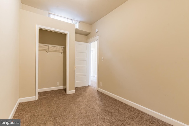 unfurnished bedroom with a closet, carpet, and baseboards