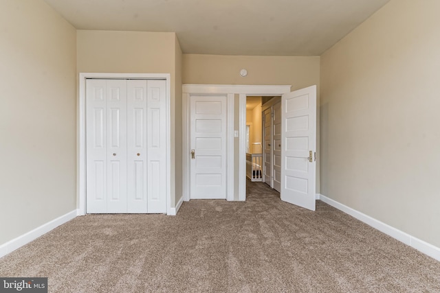 unfurnished bedroom featuring carpet floors, a closet, and baseboards