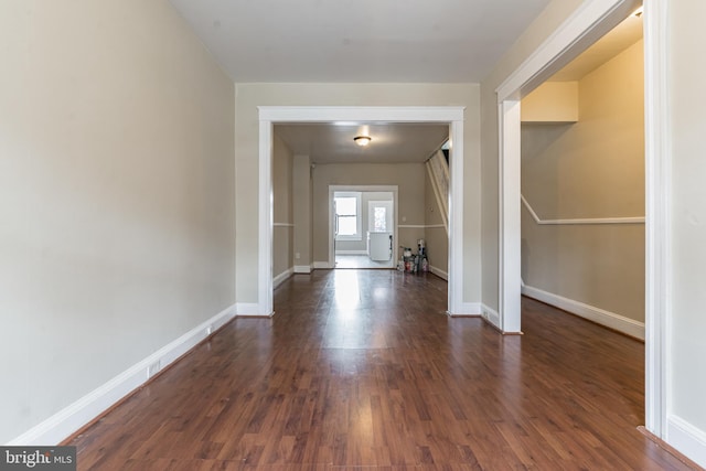 interior space featuring baseboards and dark wood finished floors