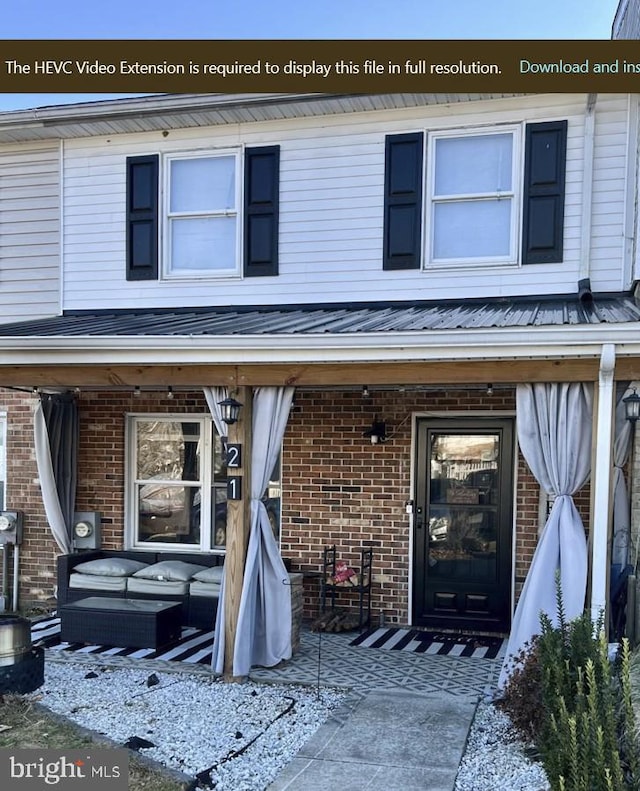 view of front of home with a porch and brick siding