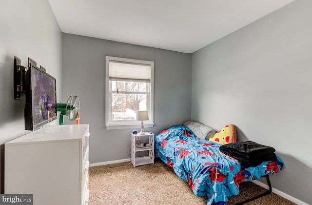 bedroom featuring light carpet and baseboards