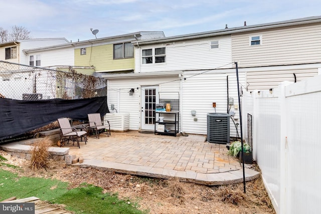 rear view of house featuring central air condition unit, a patio area, and a fenced backyard