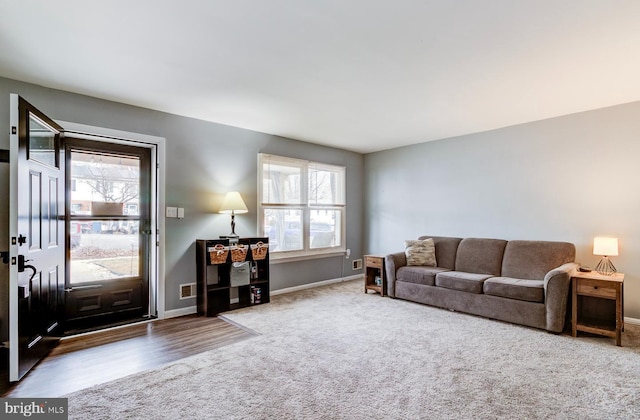 carpeted living room featuring visible vents and baseboards